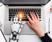 PC-Tastatur mit 2 Händen: eine Hand ist menschlich, eine Hand ist von einem Roboter